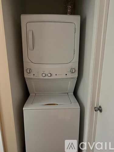A white washing machine is sitting in a small space.