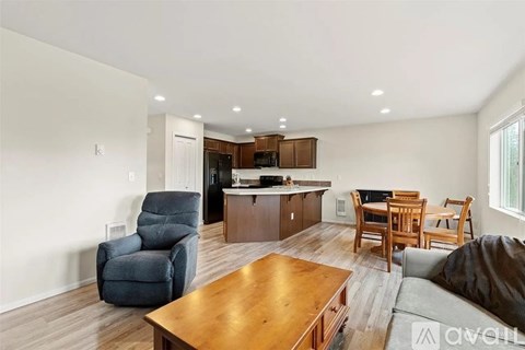 A living room with a brown wooden coffee table and a grey sofa.