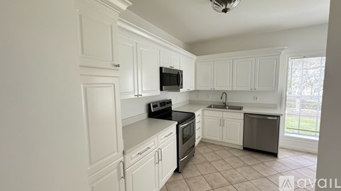 A kitchen with white cabinets and appliances.