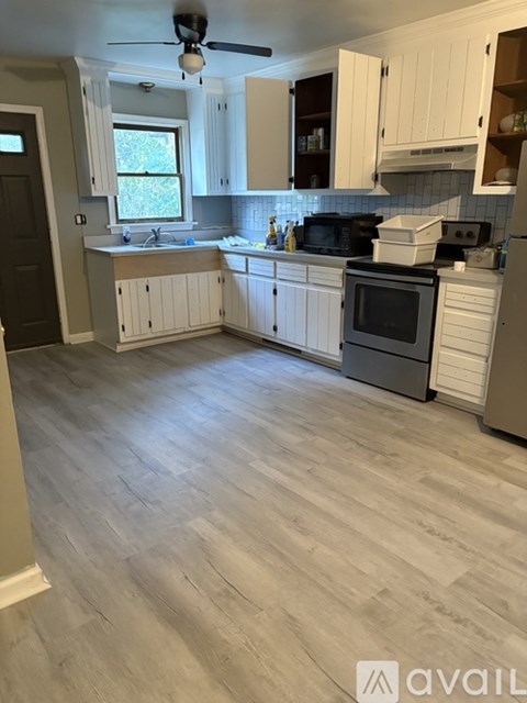 A kitchen with white cabinets and a black stove top oven.