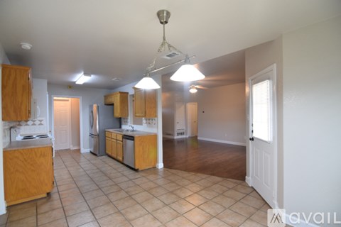 A kitchen with wooden cabinets and a tile floor.