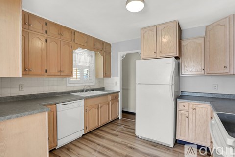 A kitchen with wooden cabinets and a white refrigerator.