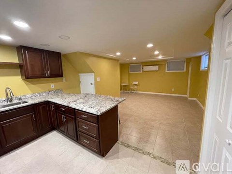 A kitchen with brown cabinets and a marble countertop.
