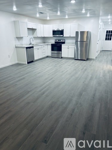 A spacious kitchen with white cabinets and stainless steel appliances.