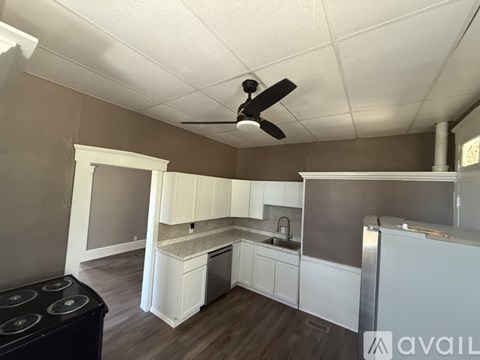 A kitchen with white cabinets and a black stove top oven.