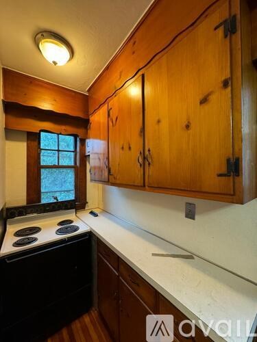 A kitchen with wooden cabinets and a black stove top.