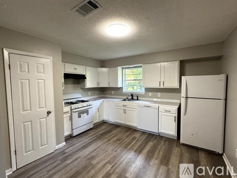 A kitchen with white appliances and cabinets.