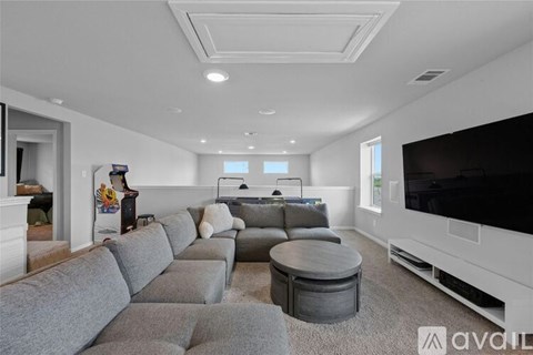 A modern living room with a grey sectional sofa and a flat screen TV.