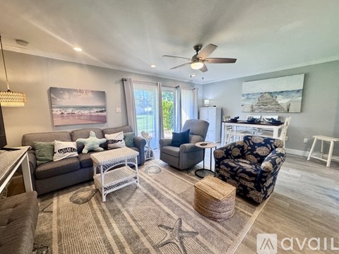 A living room with a grey couch, a black and white patterned chair, and a rug with a star design on it.