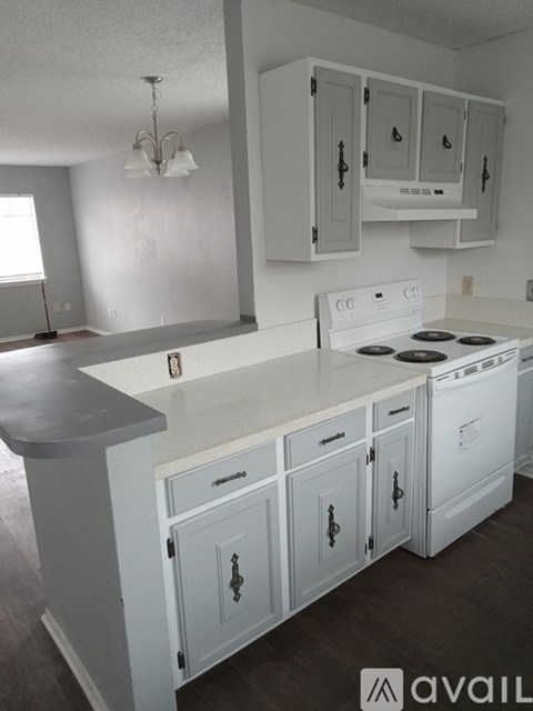 A kitchen with white cabinets and a stove top oven.