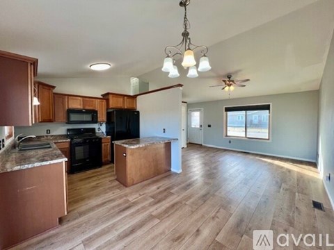 A kitchen with wooden cabinets and a black refrigerator.