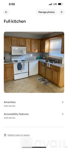 A full kitchen with wooden cabinets and white appliances.
