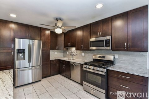 A kitchen with dark wood cabinets and stainless steel appliances.