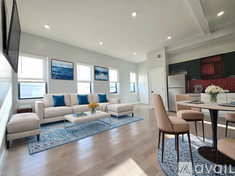 A living room with a white couch and a blue rug.