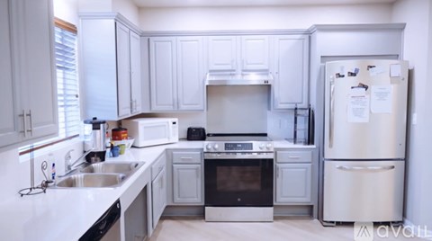 A kitchen with white cabinets and appliances.