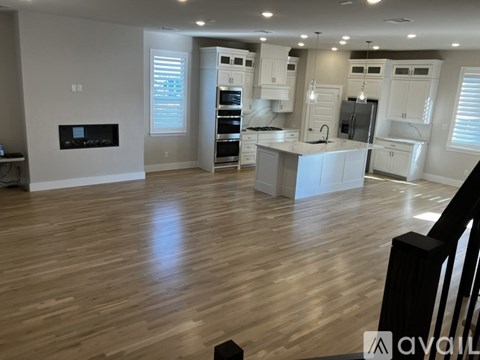 A spacious kitchen with white cabinets and a central island.