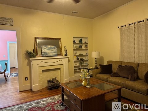 A living room with a fireplace and a painting on the wall.