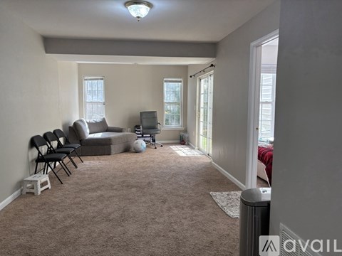 A living room with a grey carpet and a grey sofa.