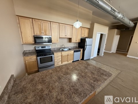 A kitchen with wooden cabinets and a granite countertop.
