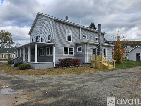 A house with a grey exterior and a yellow staircase leading to the front door.