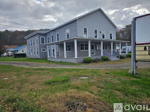 A two-story house with a grey exterior and a white porch.