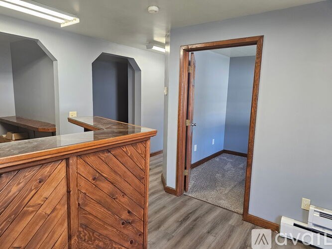 A room with a wooden desk and a mirror on the wall.