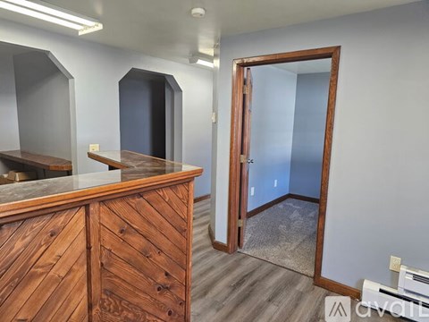 A room with a wooden desk and a mirror on the wall.
