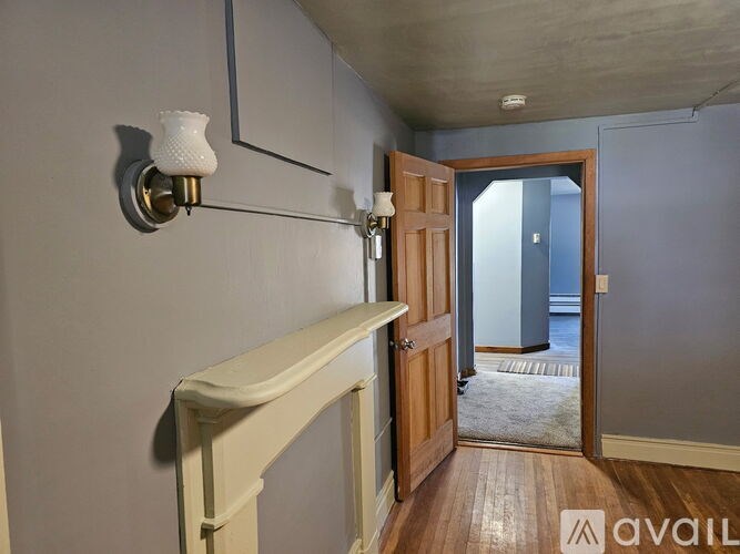 A room with a white door and a light on the wall.