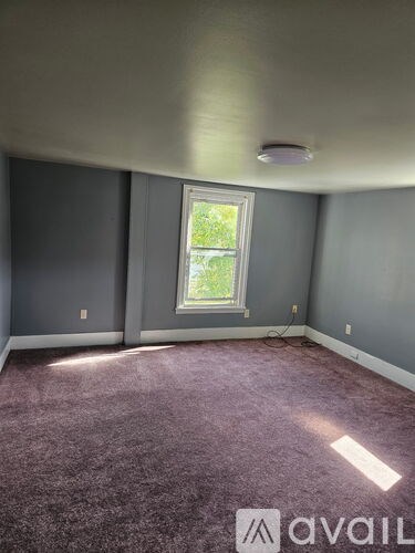A room with a window and a carpet.