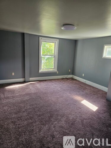 A room with a window and a carpet.