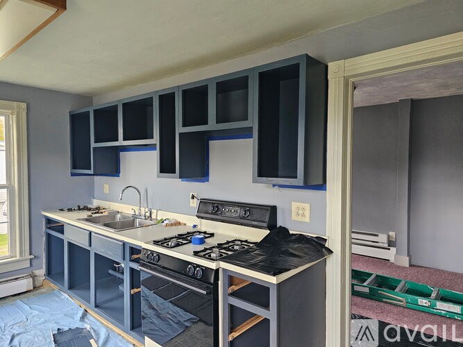 A kitchen under construction with a stove and cabinets.