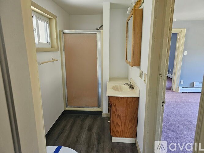 A small bathroom with a toilet, sink, and shower.