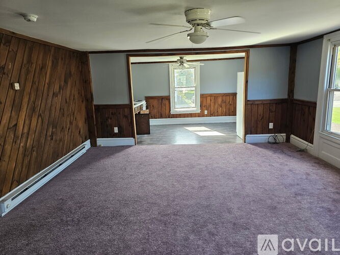 A room with wooden walls and a purple carpet.
