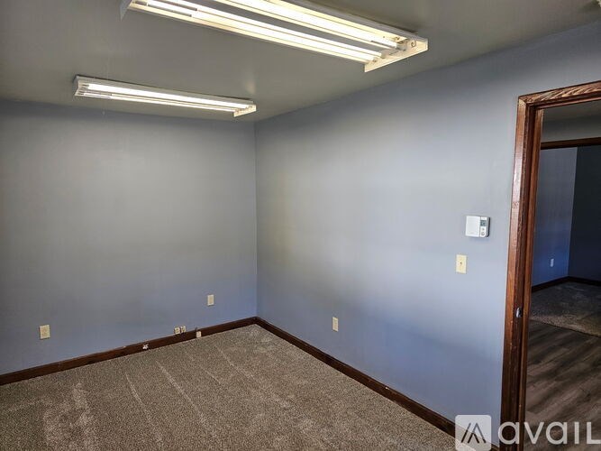 A room with a carpeted floor and a door on the right side.