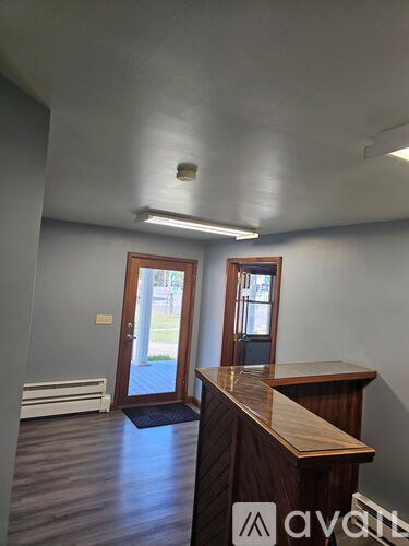 A room with a wooden desk and a window.