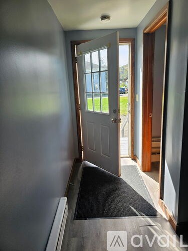 A hallway with a door leading to a balcony.