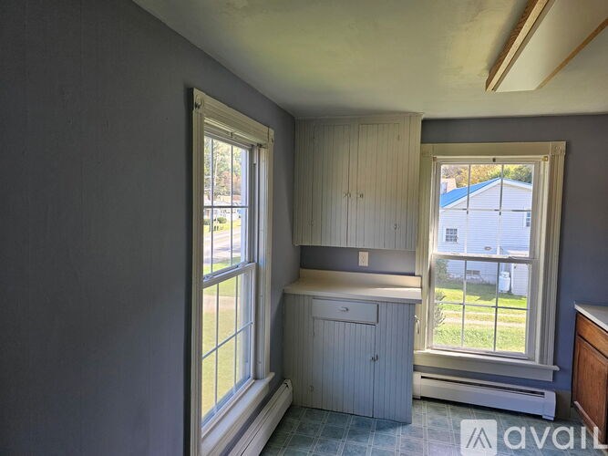 A room with a window and a cabinet is shown.
