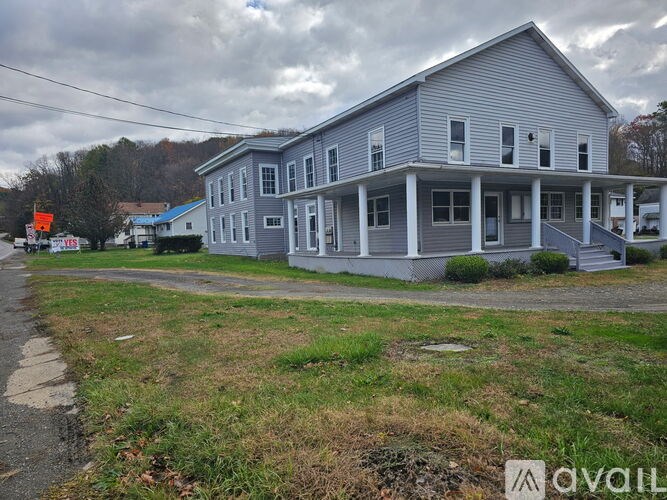 A two-story house with a grey exterior and a covered porch.