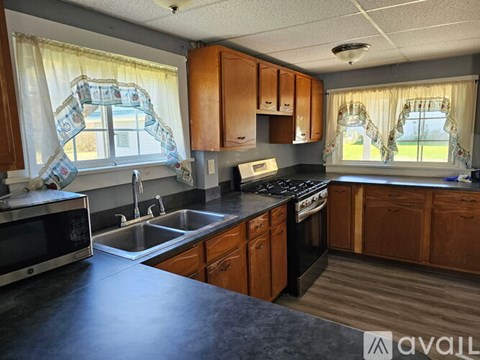 A kitchen with wooden cabinets and a black countertop.