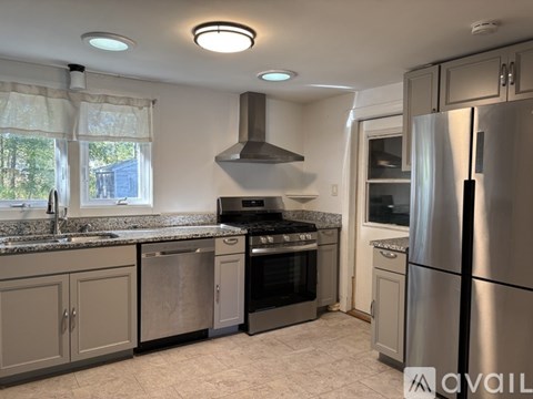 A kitchen with a stainless steel refrigerator and a black oven.