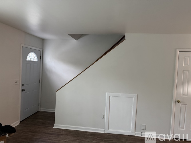 A room with a staircase and a door.