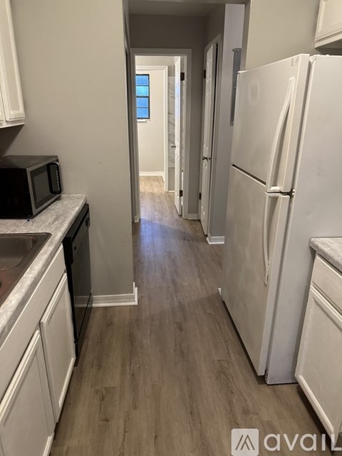 A kitchen with a white fridge and microwave.