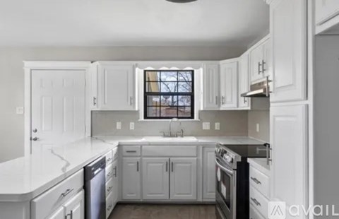A kitchen with white cabinets and appliances.