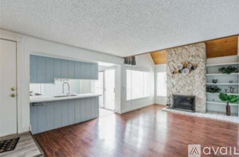 A kitchen with a sink and a fireplace in the living room.