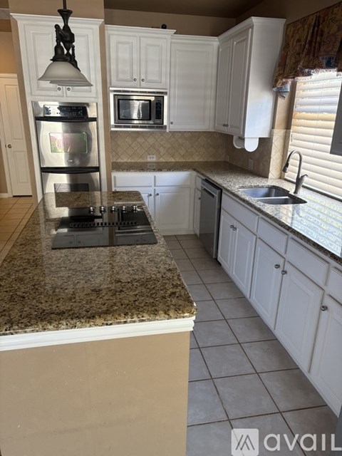 A kitchen with granite countertops and white cabinets.
