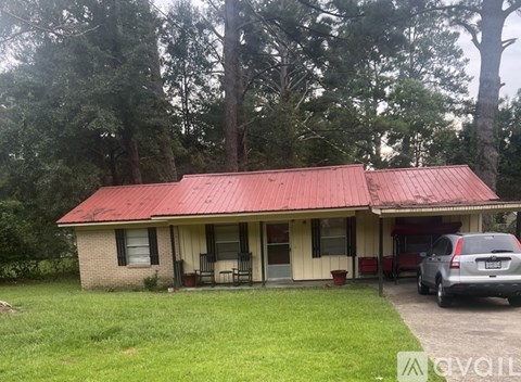 A house with a red roof and a car parked in front.