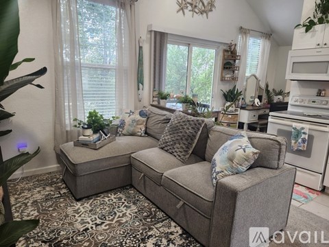 A living room with two grey couches and a rug.