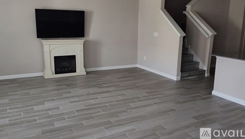 A living room with a fireplace and a television mounted above it.