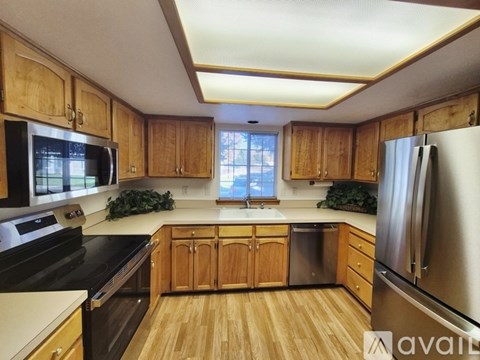 A kitchen with wooden cabinets and stainless steel appliances.