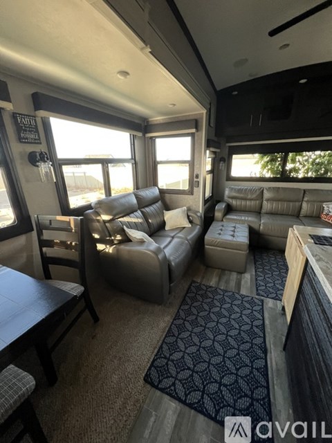 A living room with a grey couch and a black and white rug.